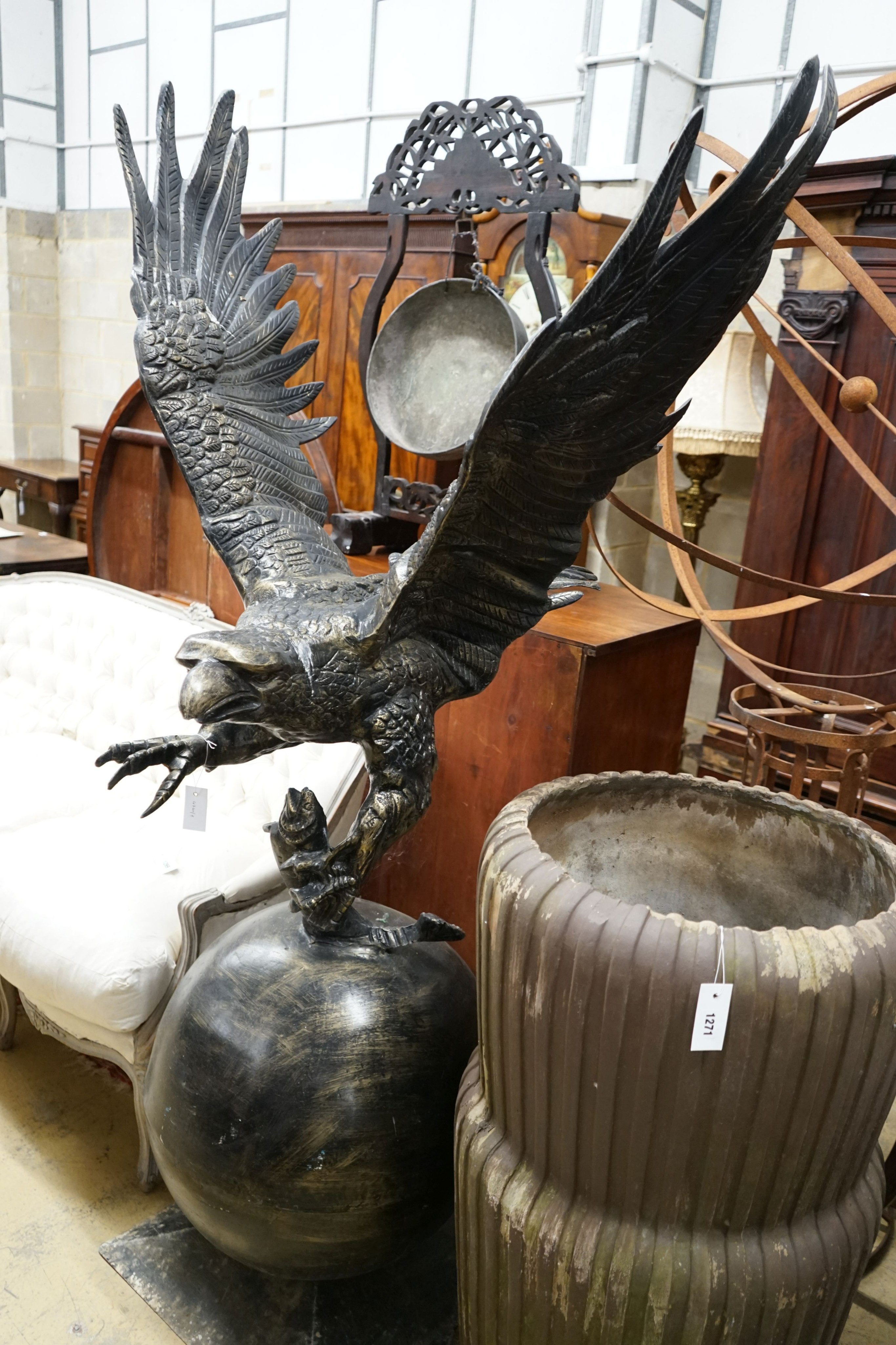A large cast metal faux bronze eagle, salmon and orb garden ornament, height 200cm